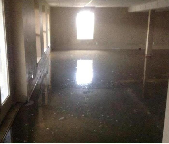 vacant building with muddy water covering the floor