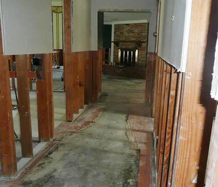 water damaged home with exposed walls and flooring removed