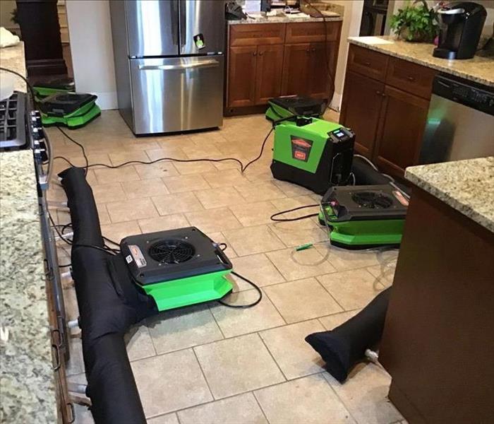 green SERVPRO equipment are attempting to dry kitchen cabinets through using an Injectidry system below the cabinets