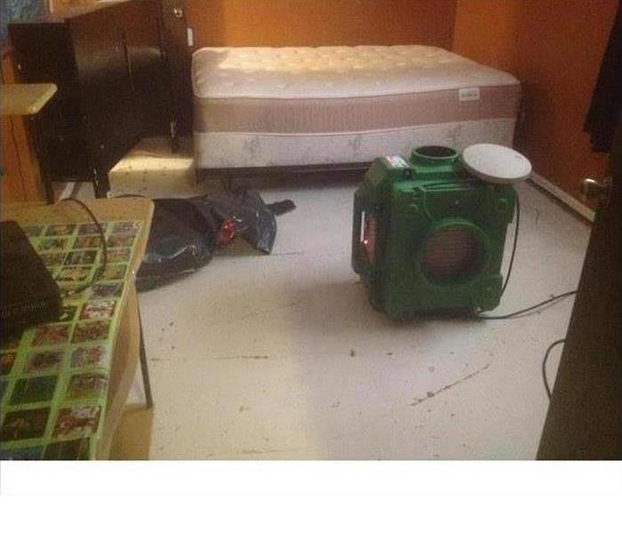 An air scrubber set up in a bedroom cleaning the air